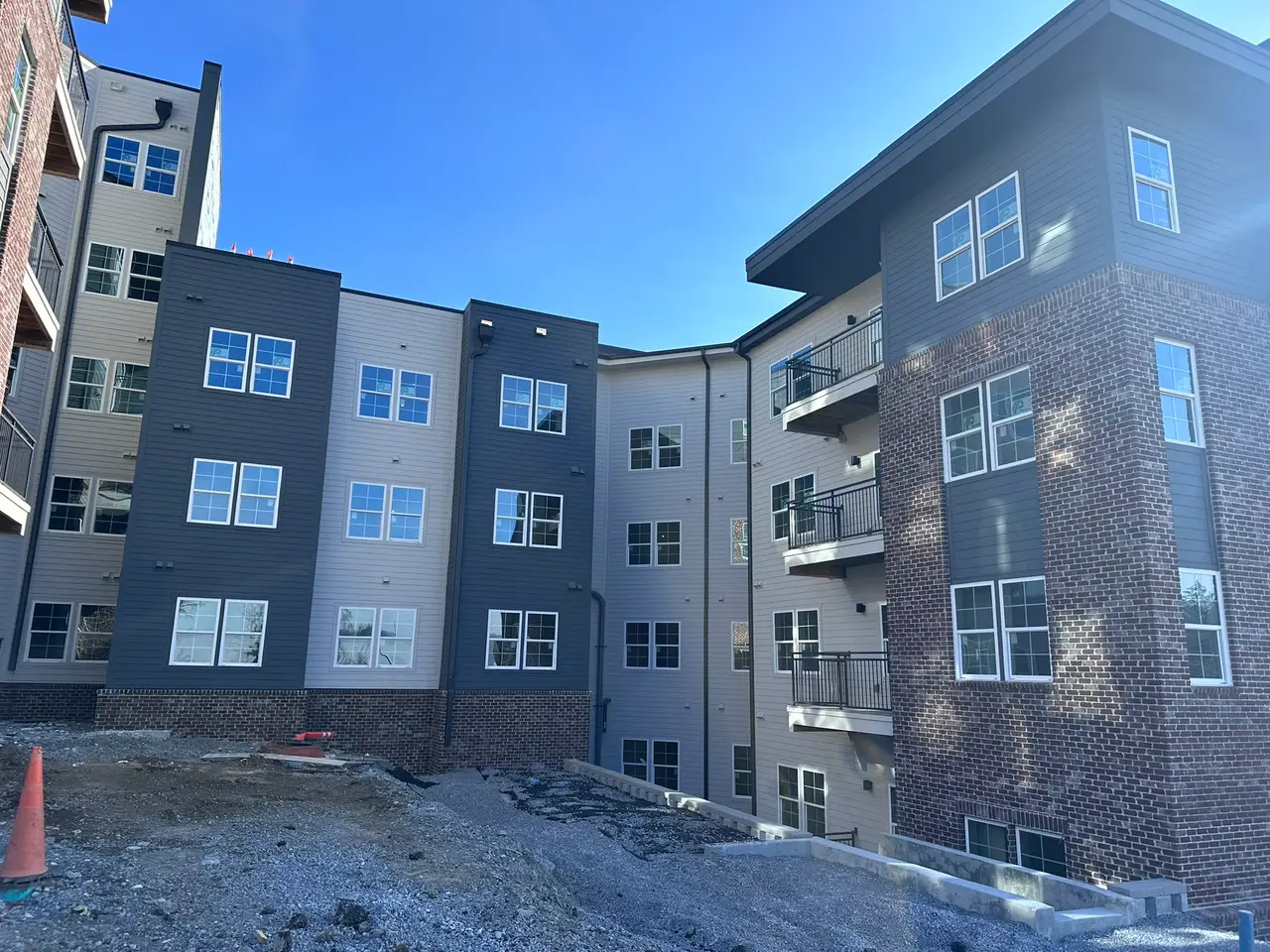 A newly completed Nashville apartment building at 3800 Clarksville Pike, its windows still carrying factory stickers before Camelot's post-construction clean